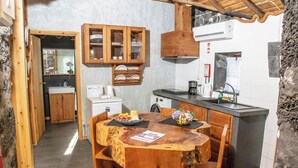 Una cucina rustica con mobili in legno, un'isola centrale e un tavolo da pranzo.