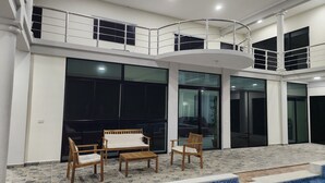 A modern interior with a pool, wooden furniture, and a balcony with metal railings.