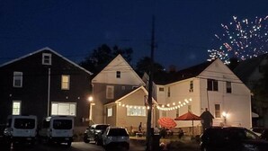 A street view at night with houses, parked cars, and fireworks in the sky. - Grand View | Walk to Falls, Casino & Attractions (Niagara Falls)