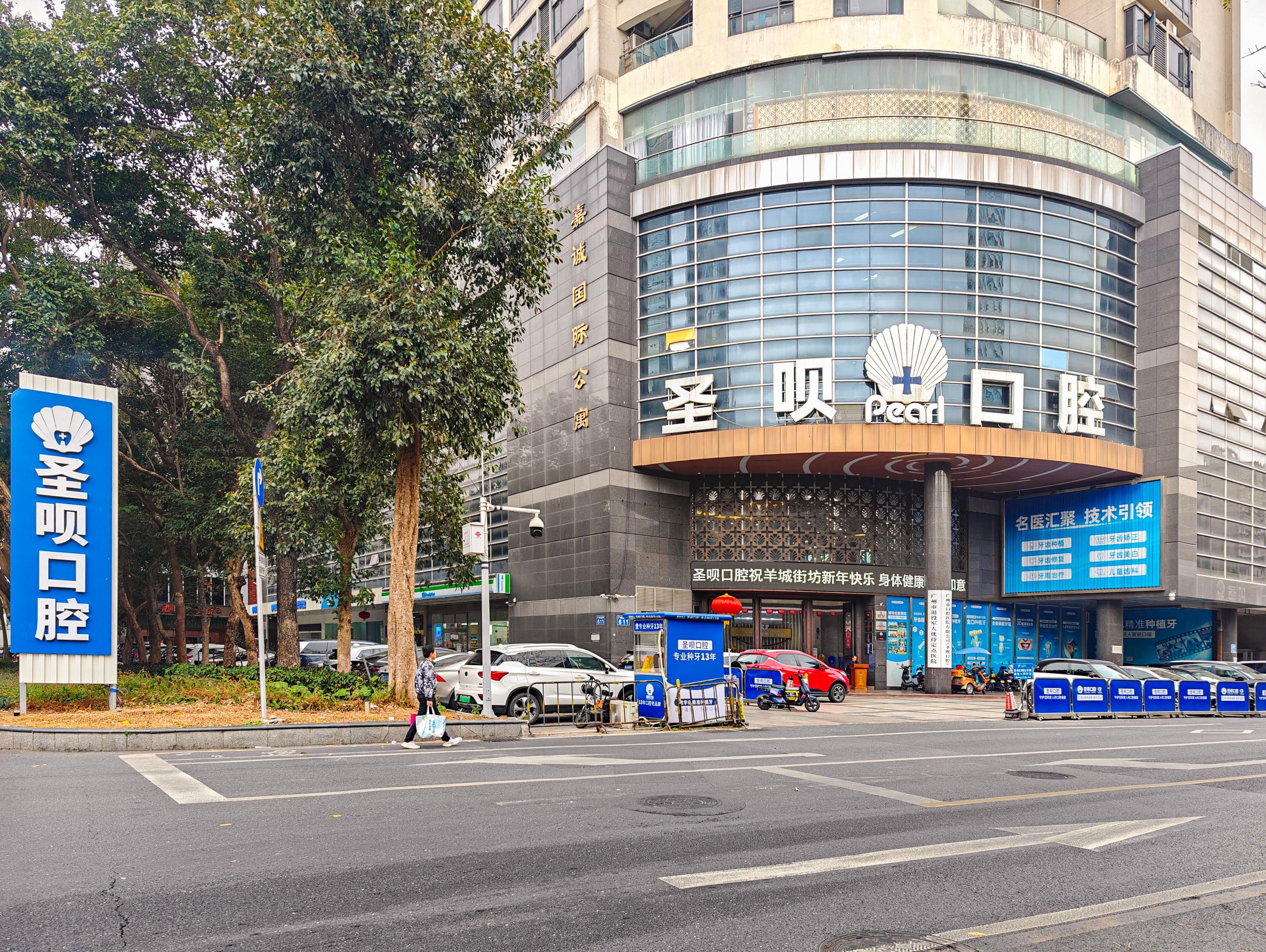 Un edificio moderno con fachada de vidrio curvo y señalización que indica que es un hotel.