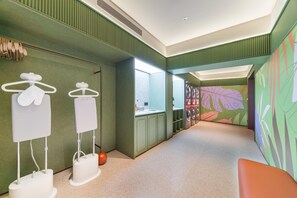 A modern bathroom with green walls, a sink, and a mirror. There are two towel racks and a toilet. - Orange Hotel Guangzhou Tianhe Sports Center (Guangzhou)