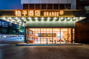 A hotel entrance with a neon sign reading "Orang" and a modern glass facade. - Orange Hotel Guangzhou Tianhe Sports Center (Guangzhou)