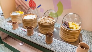 A buffet counter with various food items in wooden chafing dishes. - Orange Hotel Guangzhou Tianhe Sports Center (Guangzhou)