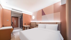 A modern hotel room with a large bed, a desk, and a small table. - Orange Hotel Guangzhou Tianhe Sports Center (Guangzhou)