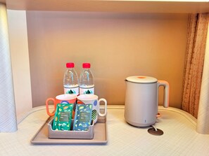 A neatly arranged tray with two water bottles, two mugs, and two tea bags on a hotel bed. - Orange Hotel Guangzhou Tianhe Sports Center (Guangzhou)