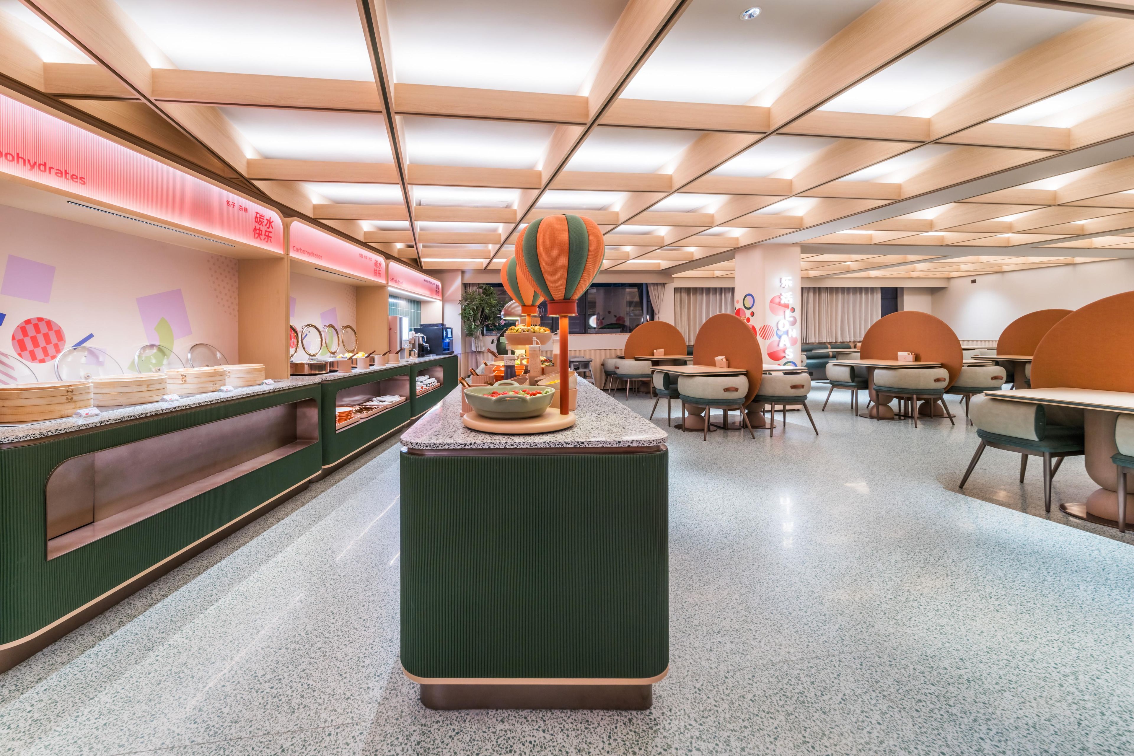 Un comedor moderno con una isla central, asientos dispuestos y una barra con alimentos.