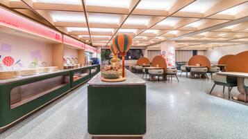 Un comedor moderno con una isla central, asientos dispuestos y una barra con alimentos.