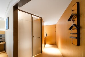 A modern hotel room with a sliding glass door, a wooden wall-mounted coat rack, and a minimalist design. - Ji Hotel Guangzhou Sanyuanli Medicine University (Guangzhou)