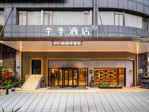 A hotel entrance with a modern design, featuring a prominent sign with Chinese characters and the word "HOTEL" in English. - Ji Hotel Guangzhou Sanyuanli Medicine University (Guangzhou)