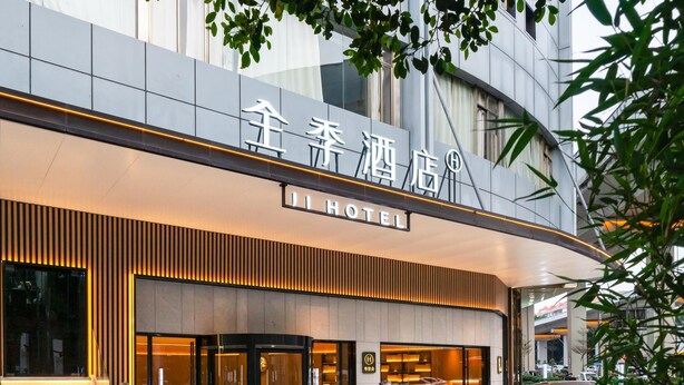 A hotel entrance with a modern design, featuring a prominent sign, a lion statue, and a staircase leading to the entrance. - Ji Hotel Guangzhou Sanyuanli Medicine University (Guangzhou)