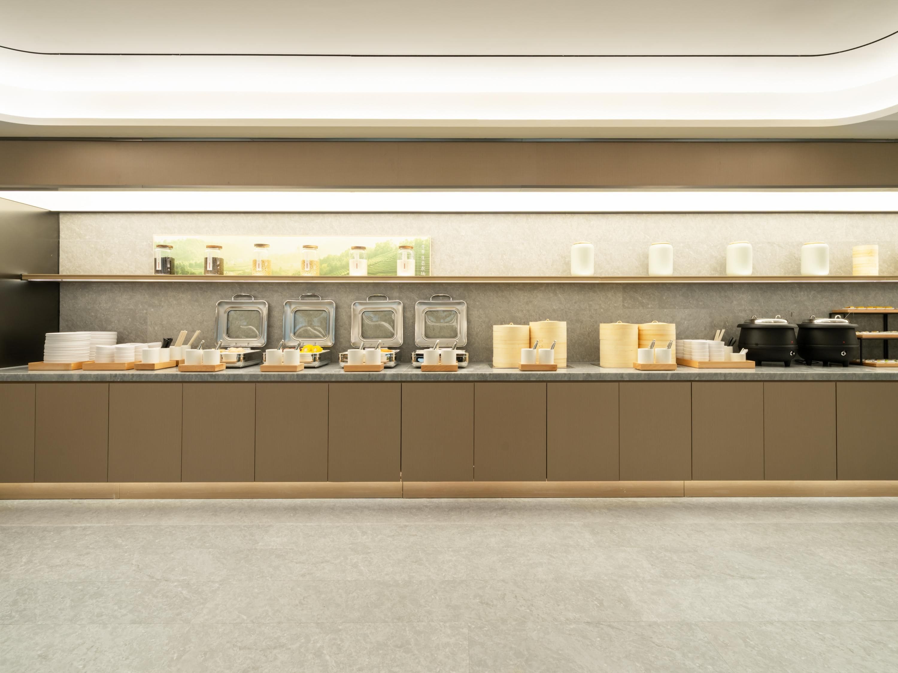 A modern kitchen with a long countertop, equipped with various appliances and utensils.