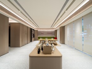 A modern, spacious hotel lobby with a central reception desk, seating area, and a green accent wall. - Ji Guangzhou Baiyun Intern Conference Center Qifu (Guangzhou)