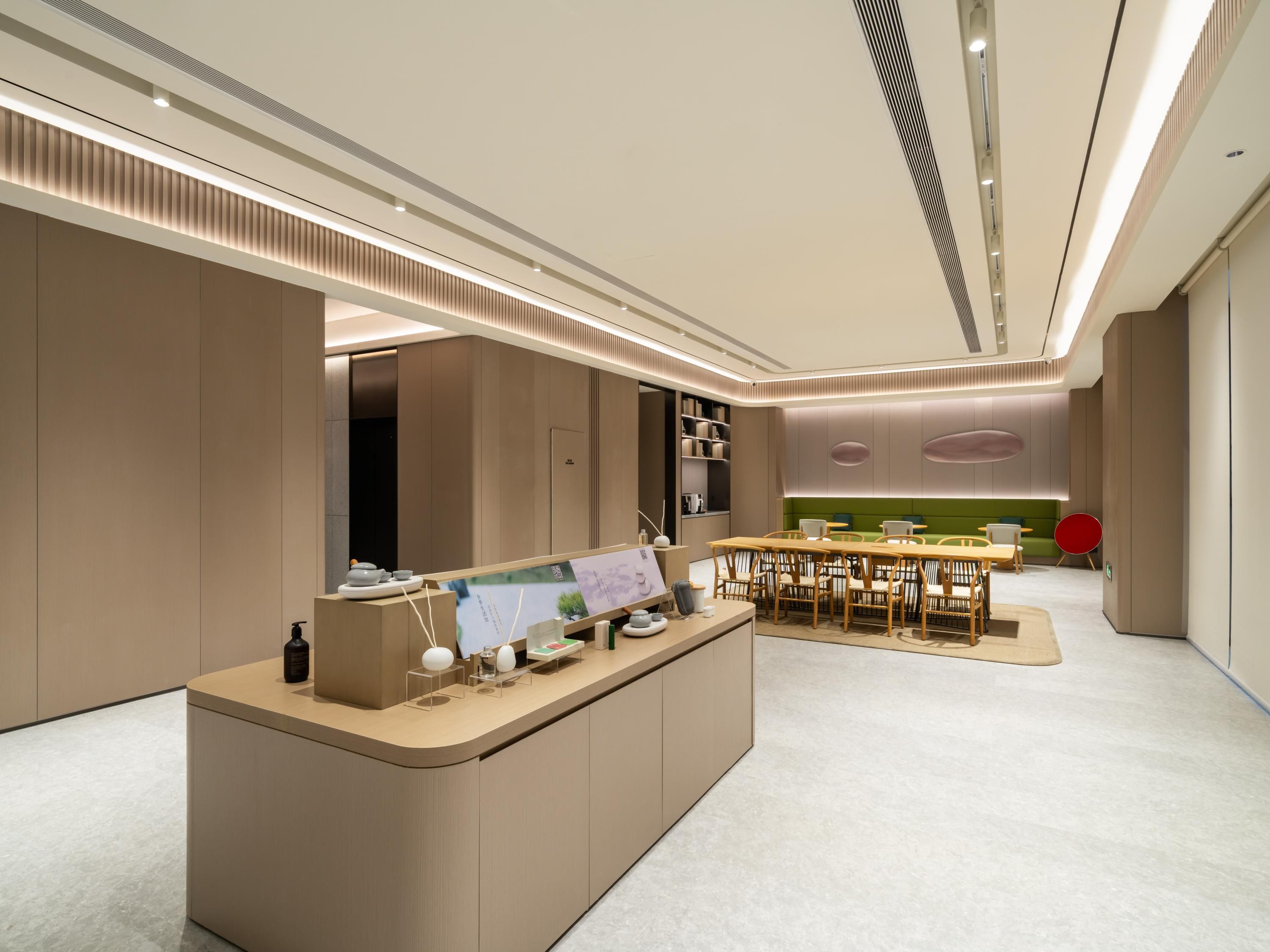 A modern, well-lit reception area with a counter, seating, and a green sofa in the background.