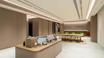 A modern, well-lit reception area with a counter, seating, and a green sofa in the background.