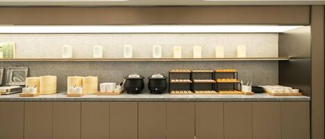 A modern kitchen with a countertop displaying various food items and appliances.