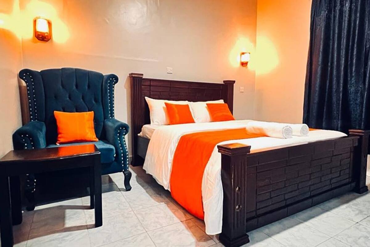 Une chambre d’hôtel avec un grand lit, une chaise et une table de chevet.
