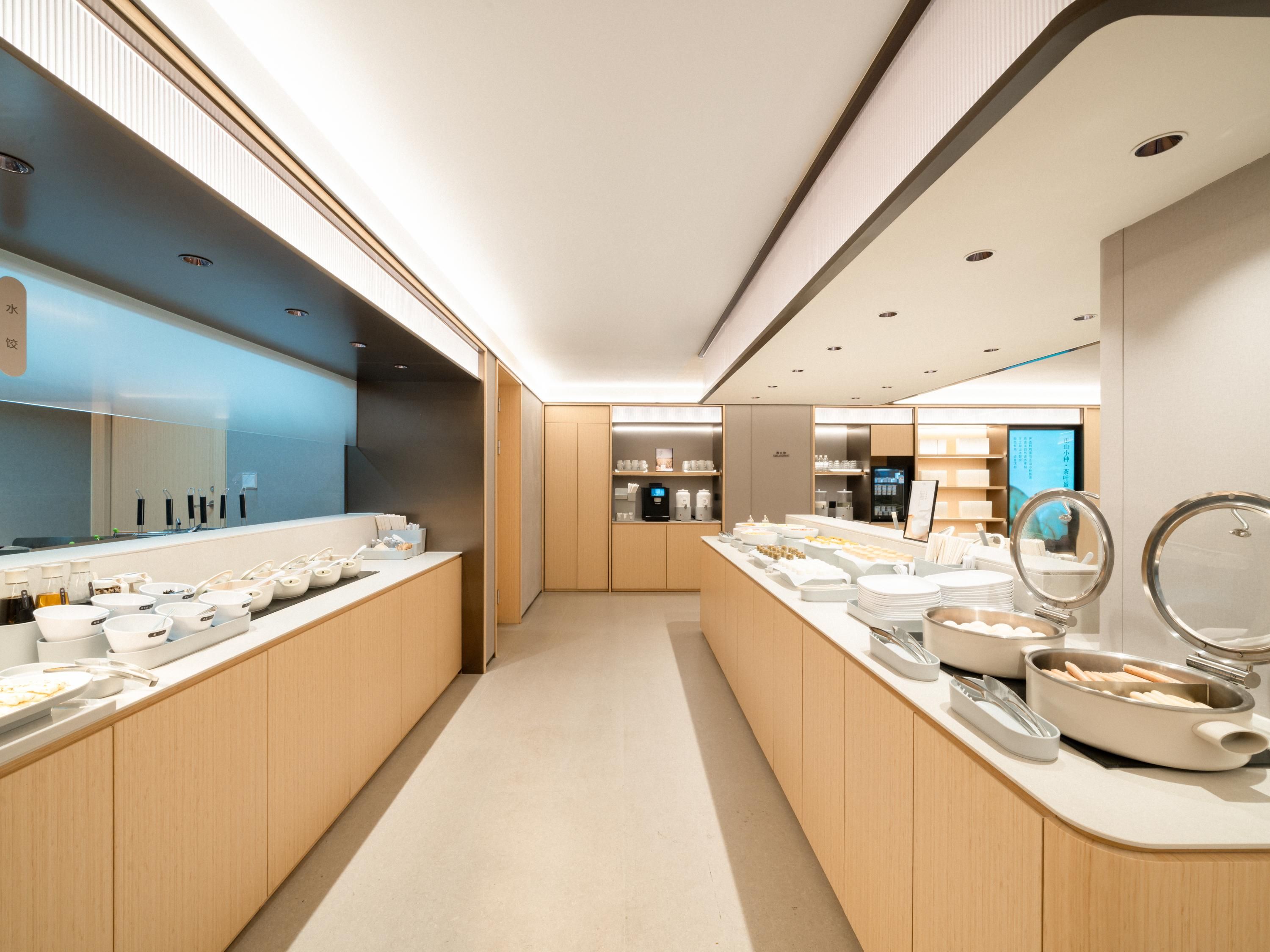 A modern kitchen with wooden cabinets, a central island with a sink, and various kitchen appliances.