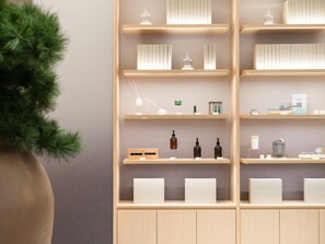 Un meuble d’étagères moderne et minimaliste, sur lequel sont exposés divers objets, notamment des bouteilles, des boîtes et des objets décoratifs.