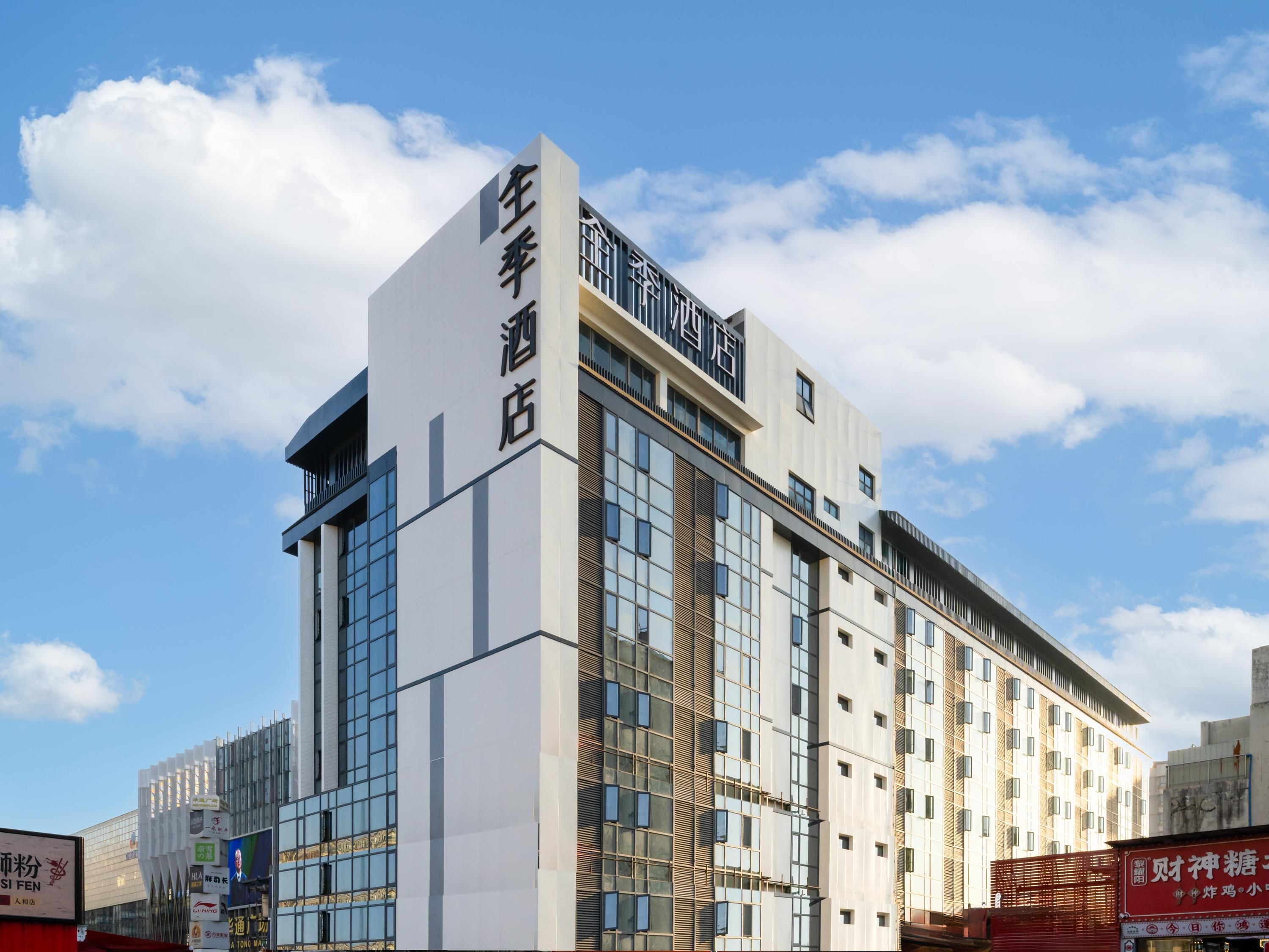A modern hotel building with a prominent sign on the facade.