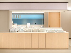 A modern kitchen with a central island, wooden cabinets, and a blue backsplash.