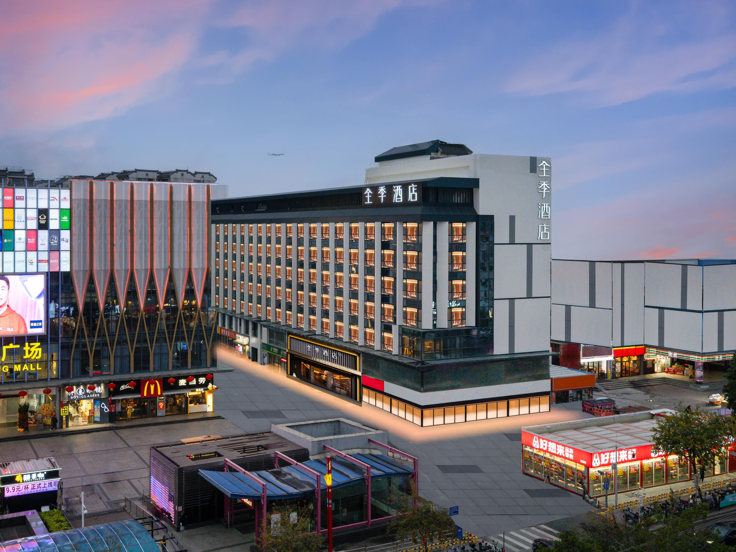 A modern hotel with multiple floors, a prominent entrance, and a large digital billboard.