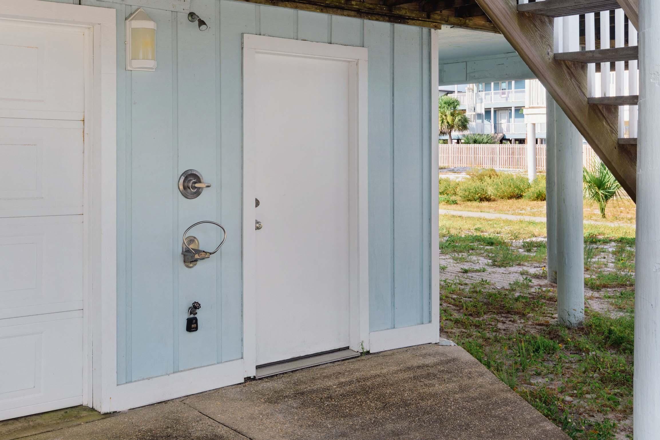 A light blue building with a white door and a small window.