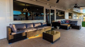 A covered outdoor seating area with wicker furniture, a glass coffee table, and ceiling fans. - 5BR w/Heated Pool & Spa Next To Downtown Chandler (Chandler)
