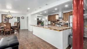 A spacious kitchen with a large island, wooden cabinets, and modern appliances. - 5BR w/Heated Pool & Spa Next To Downtown Chandler (Chandler)