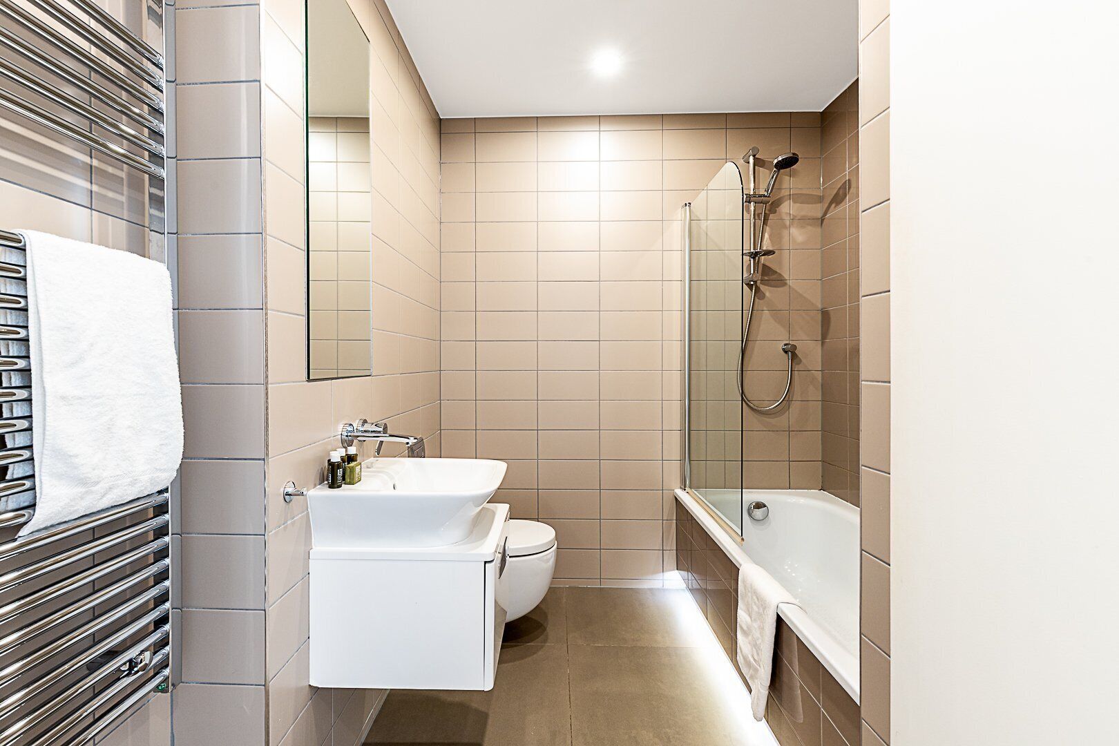 A modern bathroom with a bathtub, a sink, and a toilet.