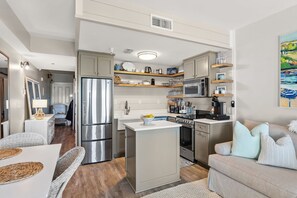 A compact kitchen with a central island, built-in appliances, and open shelving.