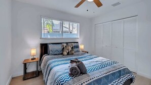 A bedroom with a bed, a ceiling fan, a window, and a nightstand. - Stylish 2BR Retreat in Miami's Design District! (Miami)