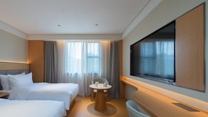 A hotel room with two beds, a TV, a small table with items, and a large window with curtains. - Ji Guangzhou Beijing Road Pedestrian St Cangbian (Guangzhou)