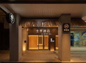 L’entrée d’un hôtel, avec une enseigne indiquant « 全季酒店 » (Jin Qiu Hotel).