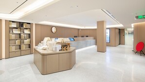A modern reception area with a curved desk, a digital kiosk, and a bookshelf. - Ji Guangzhou Beijing Road Pedestrian St Cangbian (Guangzhou)