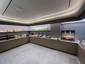 Une cuisine moderne et bien éclairée, dotée d’un long comptoir, de divers appareils électroménagers et d’éléments de rangement.