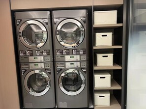 A laundry facility with two front-loading washing machines and four storage bins. - Ji Guangzhou Beijing Road Pedestrian St Cangbian (Guangzhou)