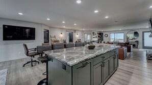 A spacious kitchen with a large island, modern appliances, and ample counter space. - Cozy Haven - 4 En-Suite BR + Hot Tub + Fire Pit (Lead)