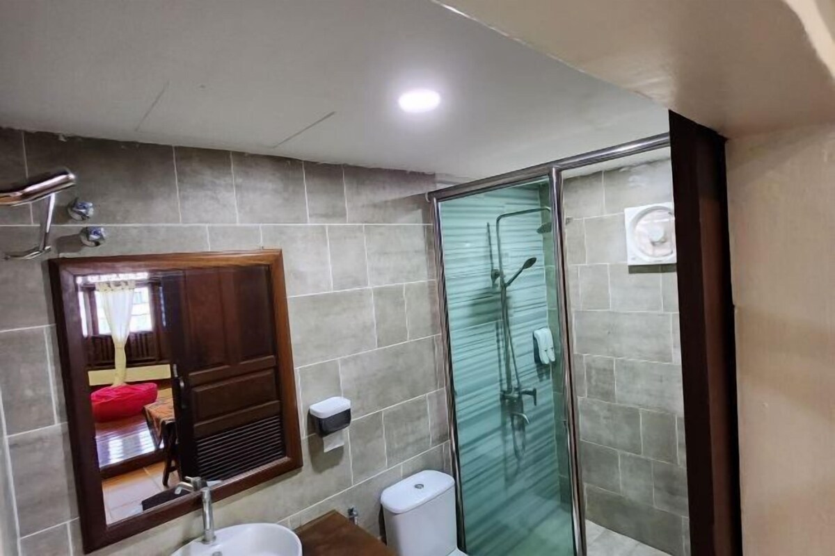 A bathroom with a glass shower enclosure, a sink, and a toilet.
