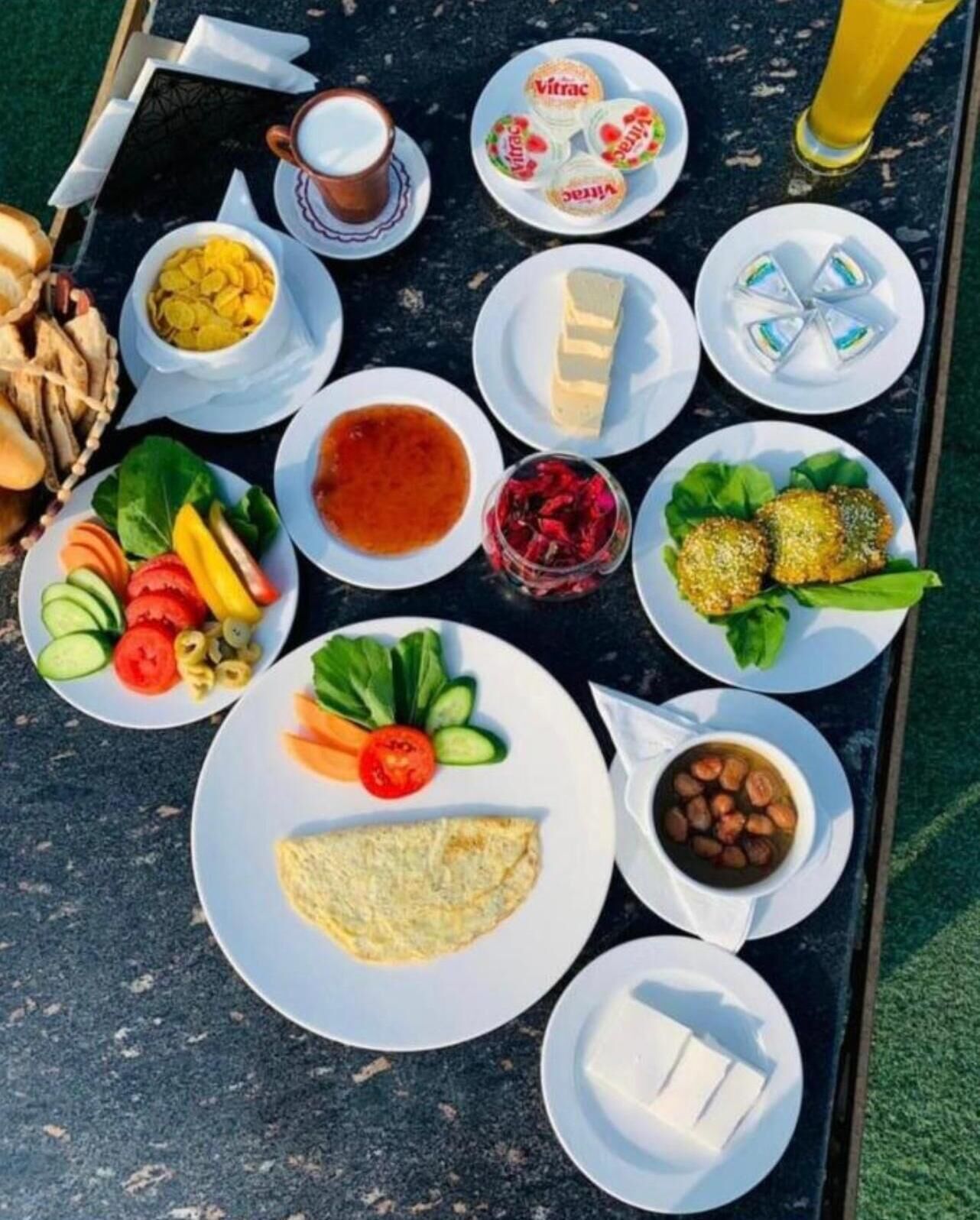 Et bord med forskellige morgenmadsvarer, herunder æg, yoghurt og frugt.