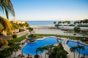 A resort with a large pool area, palm trees, and a beach view. - Las Mañanitas LM E3402 (San José del Cabo)