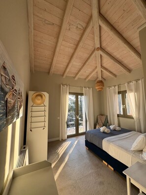 Une chambre à coucher avec un lit, une fenêtre avec des rideaux, un ventilateur de plafond et un tableau accroché au mur.