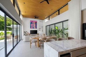 Un intérieur moderne comprenant un coin repas, un canapé et un téléviseur.