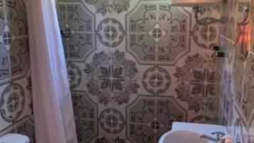 A bathroom with a toilet, sink, and shower curtain.