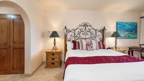Un dormitorio con una cama, dos mesitas de noche, un armario de madera y un cuadro en la pared.