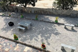 Un espace extérieur aménagé avec des bancs en pierre et des plantes en pot.
