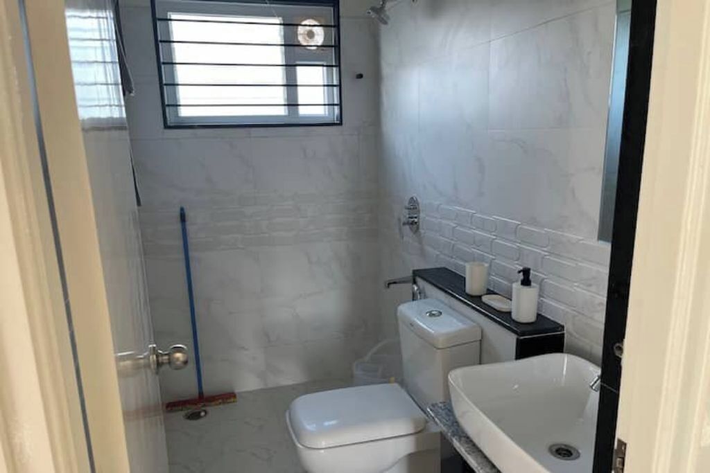 Een kleine, praktische badkamer met toilet, wastafel en douche.