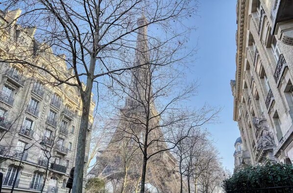 A tall building with a classical architectural style, surrounded by other buildings with ornate facades and balconies. - [120 m2] Luxury Eiffel Signature (Paris)