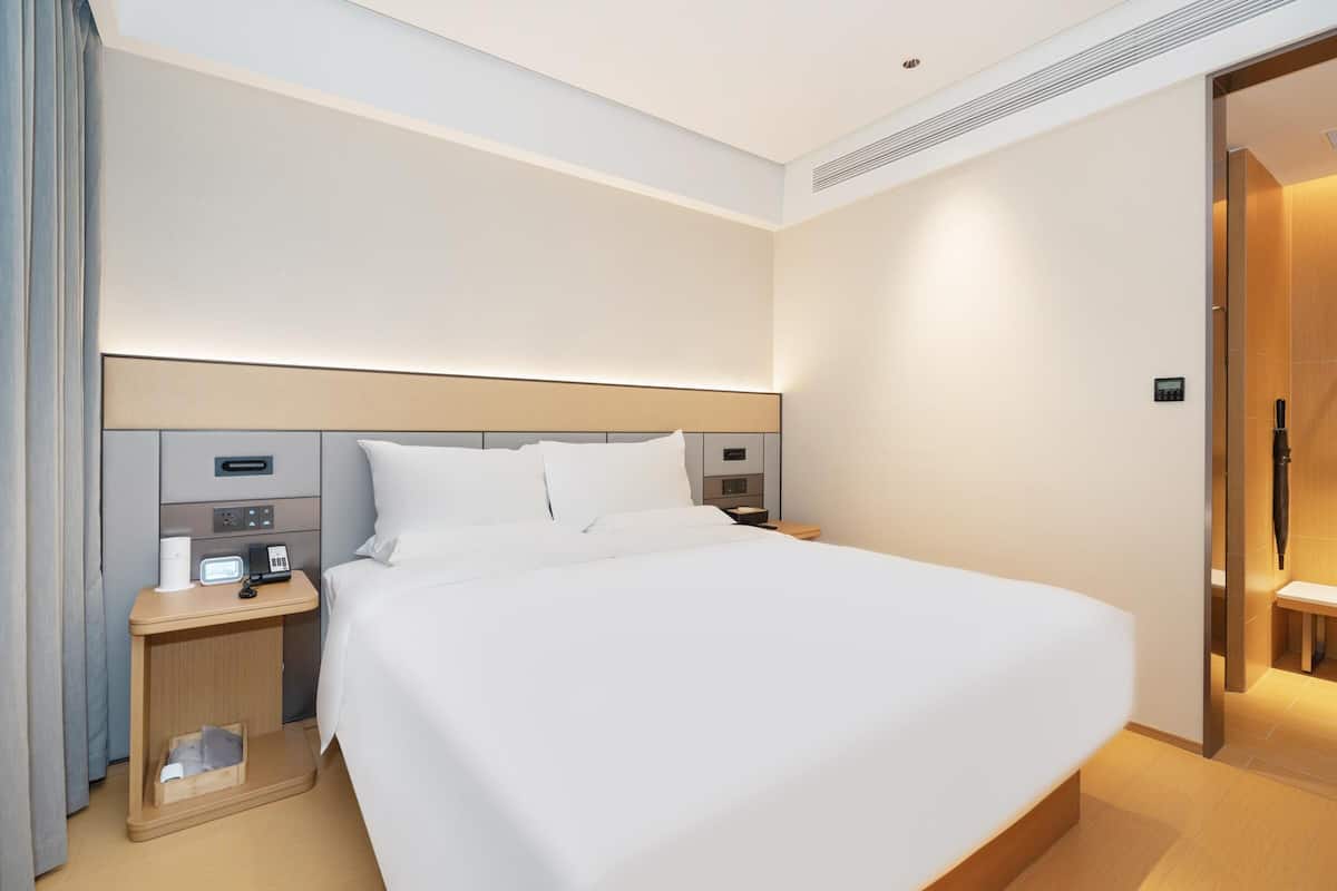 Ein Hotelzimmer mit einem großen Bett, Nachttischen und einem modernen Design.