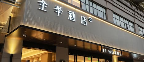 The exterior of Ji Hotel with illuminated signage and a modern facade.