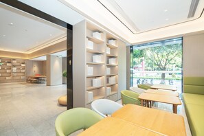 A modern interior with a seating area, bookshelves, and a view of the outdoors. - Ji Hotel Guangzhou Fangcun Huadiwan (Guangzhou)